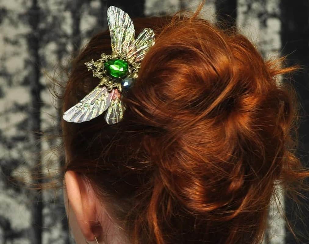 girl with brown messy bun with dragonfly jewelry
