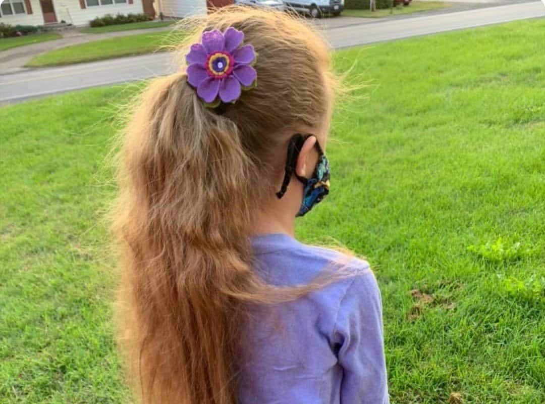 girl with blonde ponytail with flower